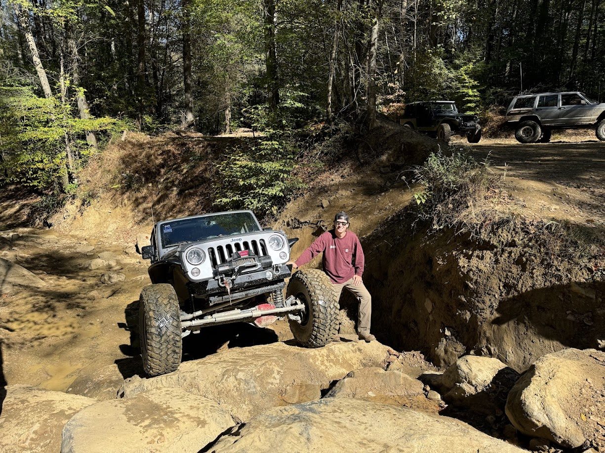 Silver Jeep flexed on a rocky trail