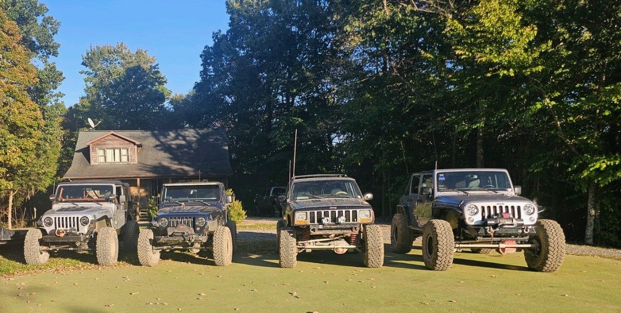 Four modified Jeeps lined up after a trail trip